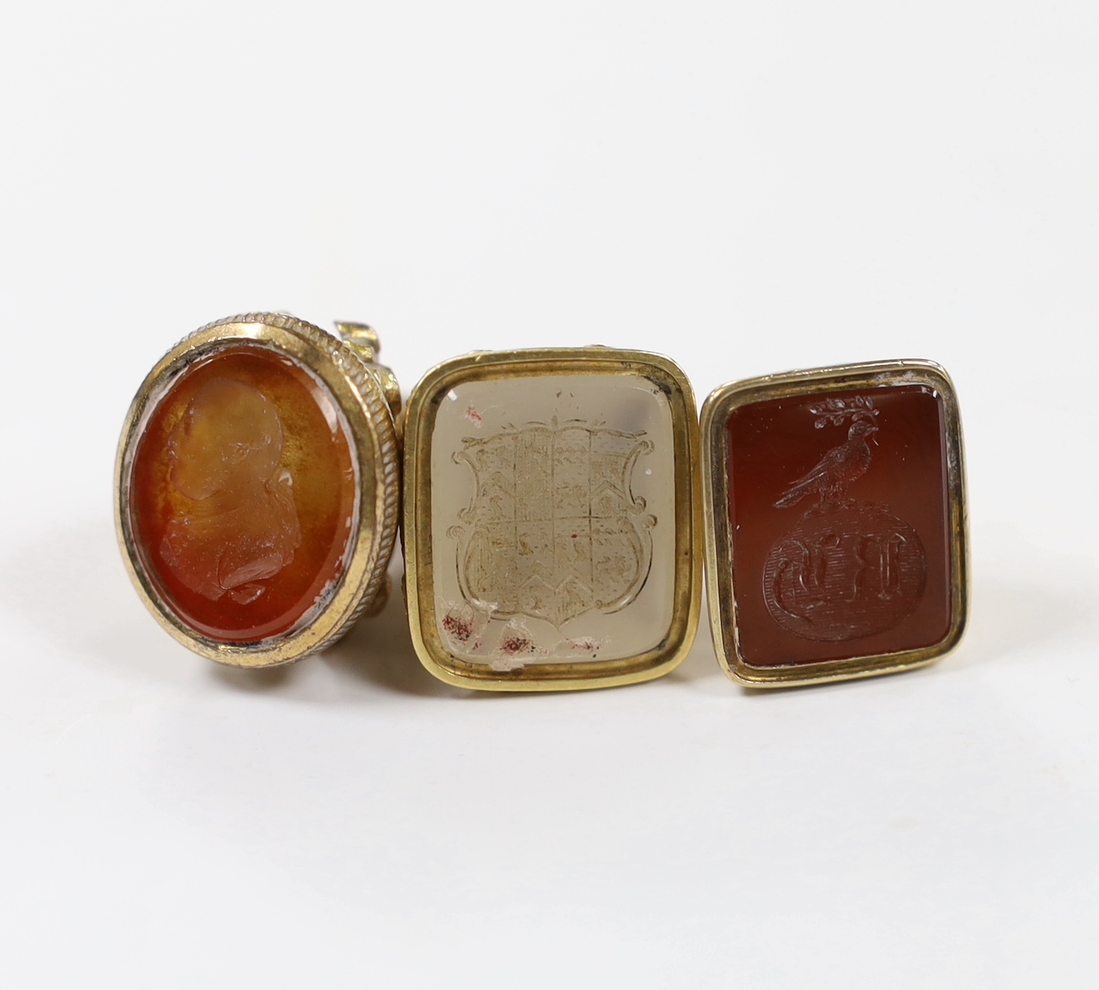 Three assorted 19th century carnelian set fob seals, including one gold plated and two yellow metal overlaid, largest 30mm.